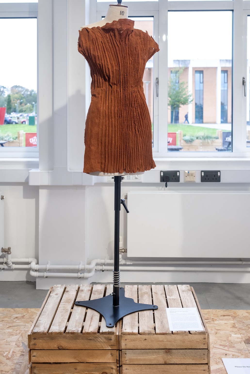 A brown ugandan barkcloth dress on a mannequin 